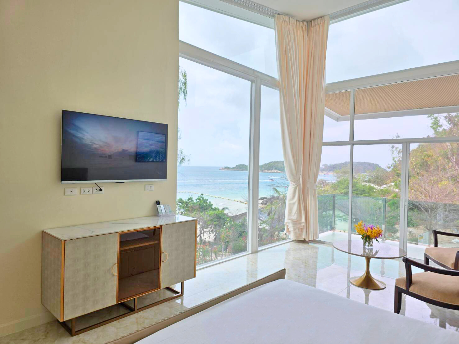 Comfortable bed with TV and ocean view from the Sea View Room at Ta Yai Beach Resort, Koh Larn